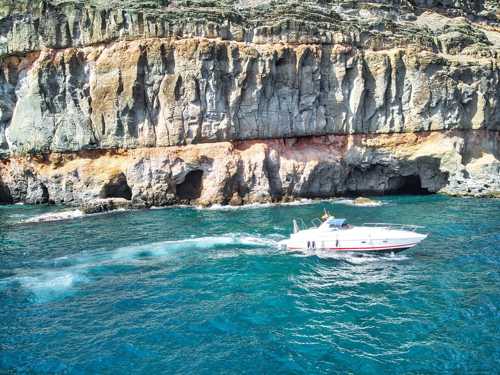 Grutas marinhas e águas turquesa na costa de Puerto de Mogán